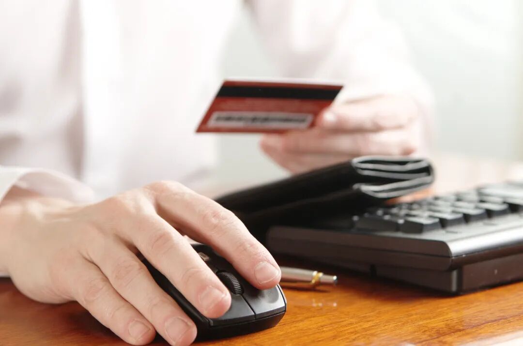 千库网_电脑键盘上有钱包和银行卡的商人的手_摄影图编号13851913.jpg