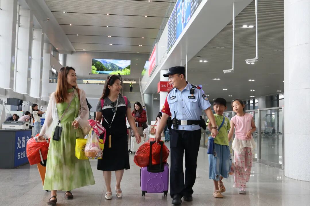 天津铁路公安处北戴河站派出所民警帮助旅客拿行李,确保旅客和儿童能够顺利乘车。.JPG